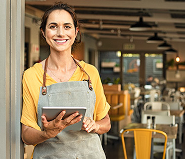 Betriebshaftpflichtversicherung - Café-Besitzerin mit Tablet in der Hand